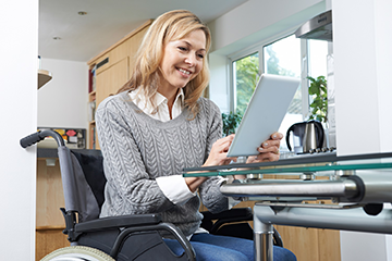 Woman in a wheelchair using a tablet computer